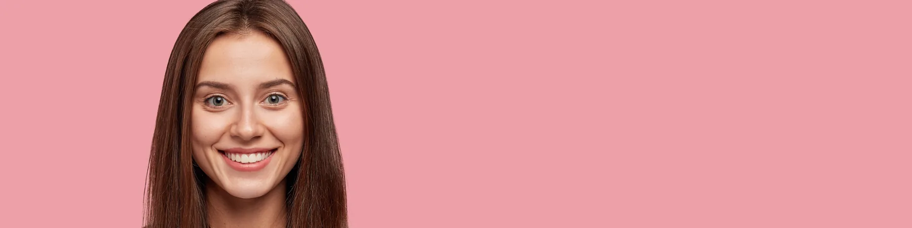 A smiling woman gesturing to one side.